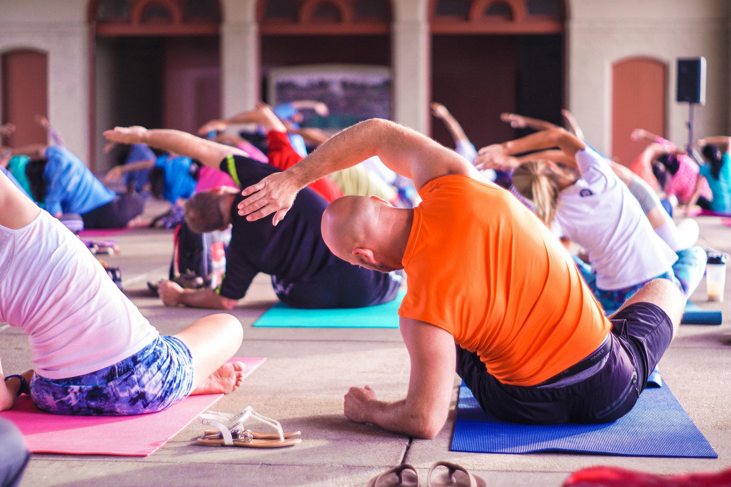 A group of people performing stretching exercises on yoga mats.