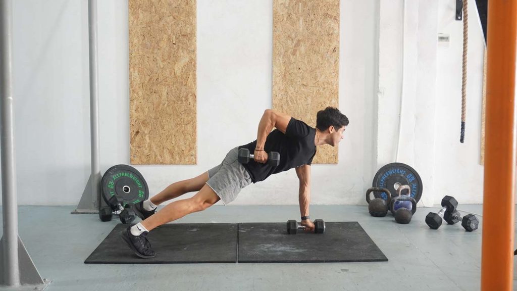 A man performing a renegade row with dumbbells while in a plank position.