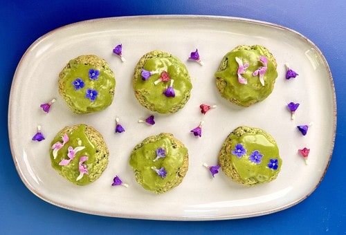 A single round nettle cookie with a smooth matcha icing finish on a plate.