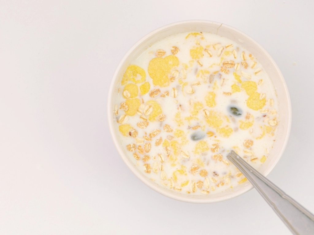 A bowl of high-fiber whole grain cereal with milk.