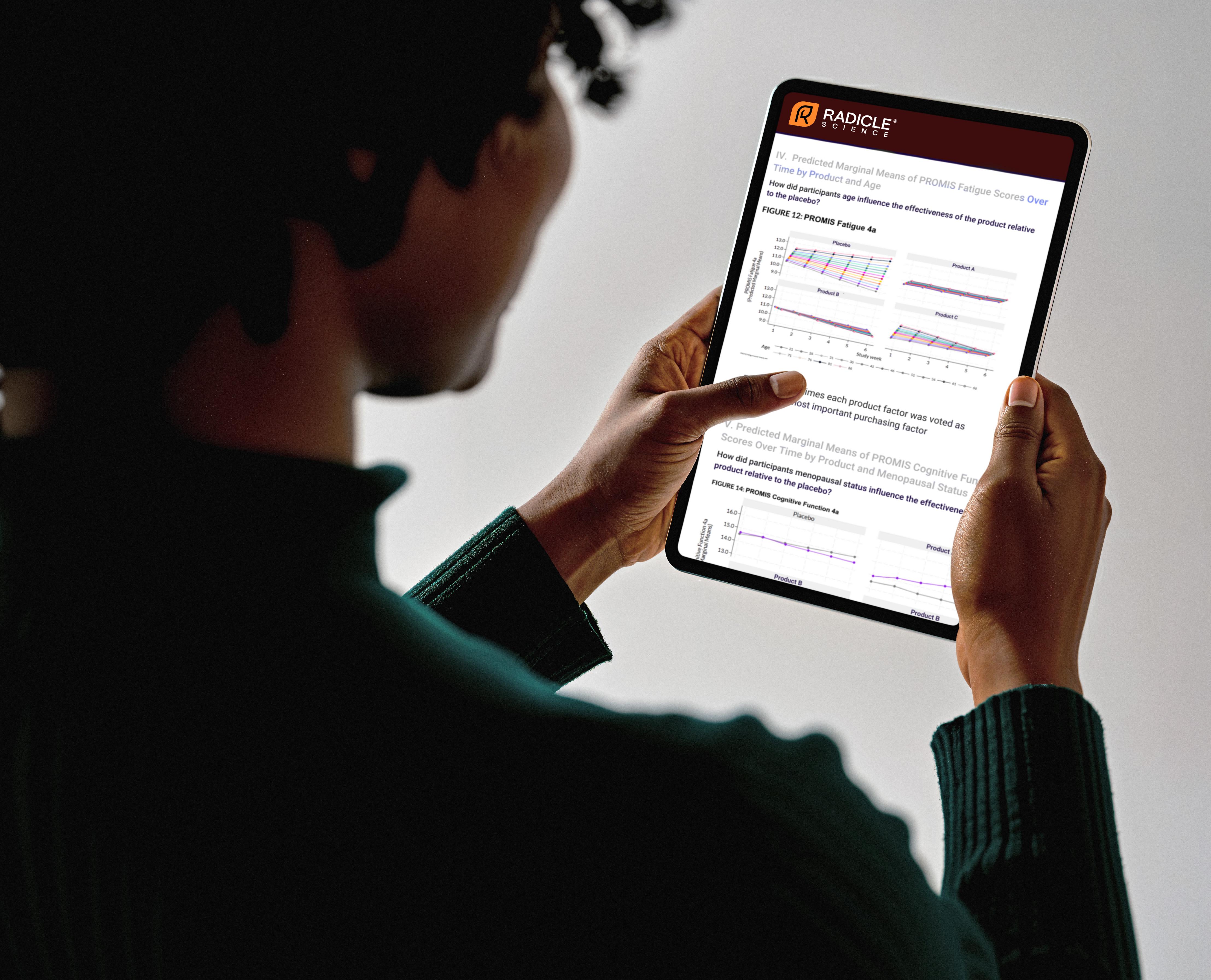 A person using a digital tablet to analyze personal health biomarkers and supplement efficacy charts.