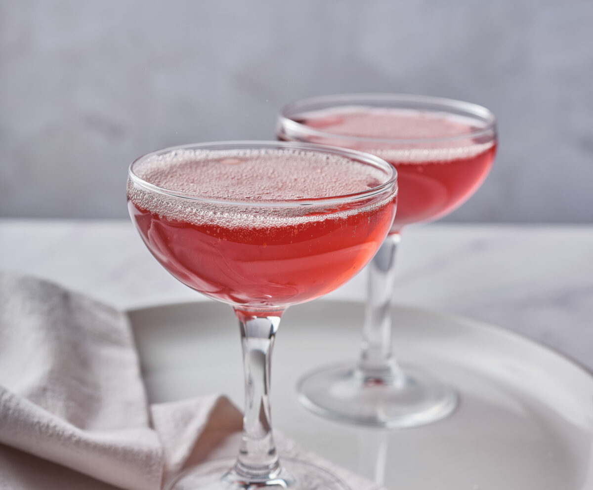 A Pomegranate Gin Fizz served in an aesthetic home setting.