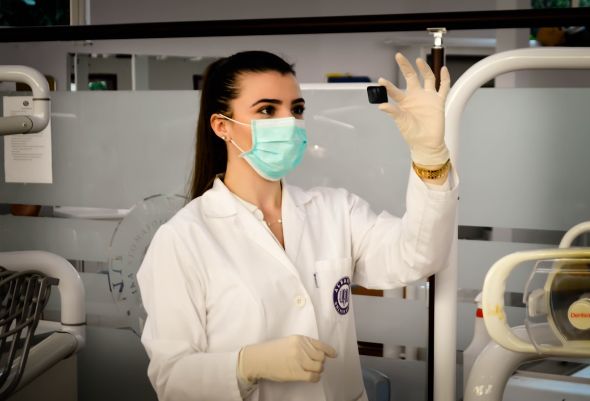 A doctor in a white coat holding a clipboard while talking to a patient.