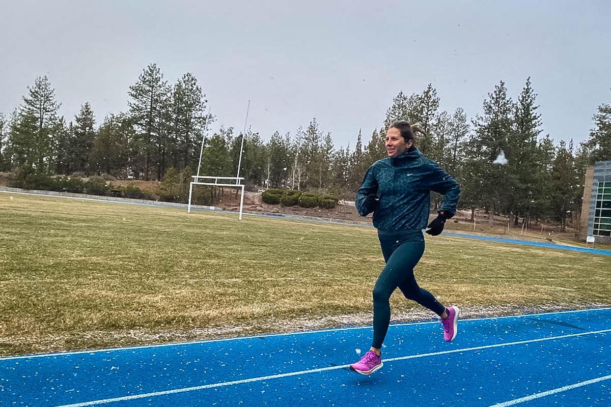 A runner on a snow-dusted track demonstrating winter training.