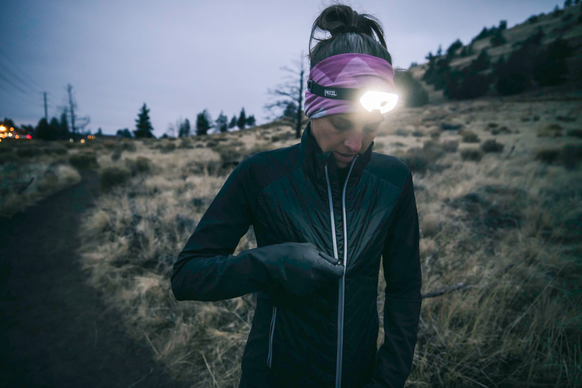 A person zipping up a warm hybrid jacket for outdoor winter activity.