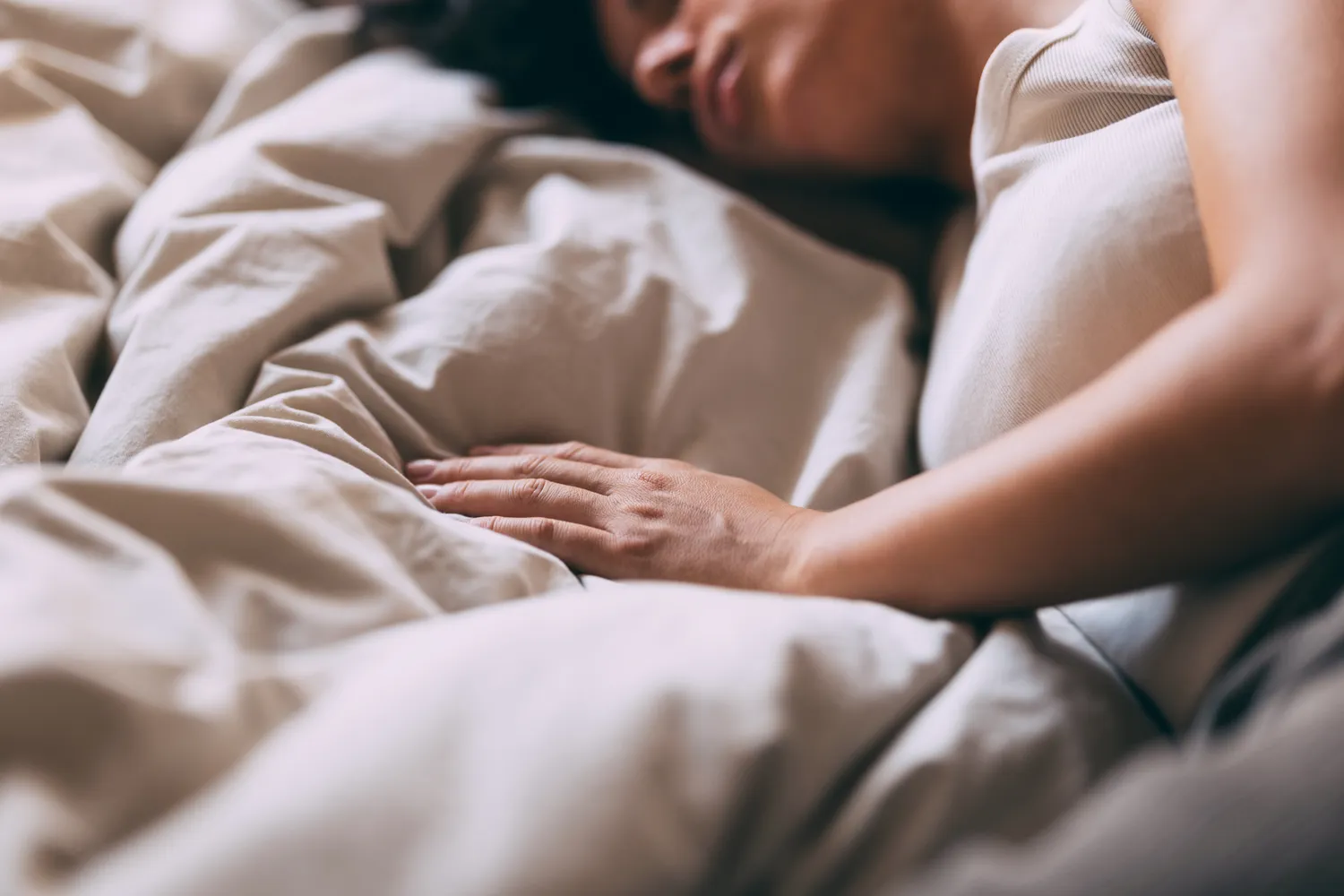 A person resting peacefully under soft blankets, illustrating health recovery.