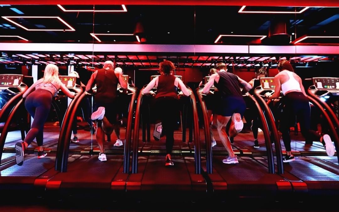 Athletes training intensely on treadmills in a boutique gym setting