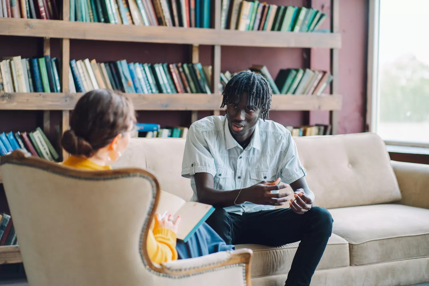 A young man in a clinical consultation discussing his well-being with a professional.