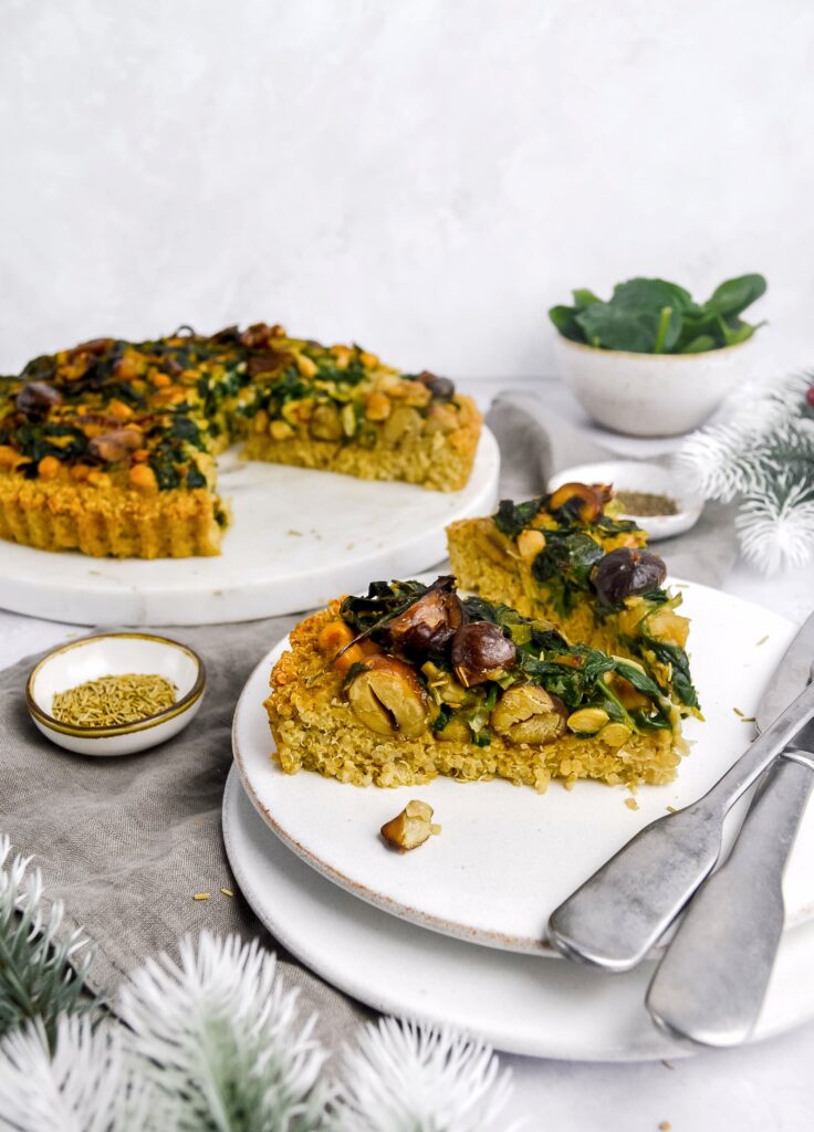 A close-up view of a sliced chickpea and spinach tart, showing the dense, protein-rich texture.