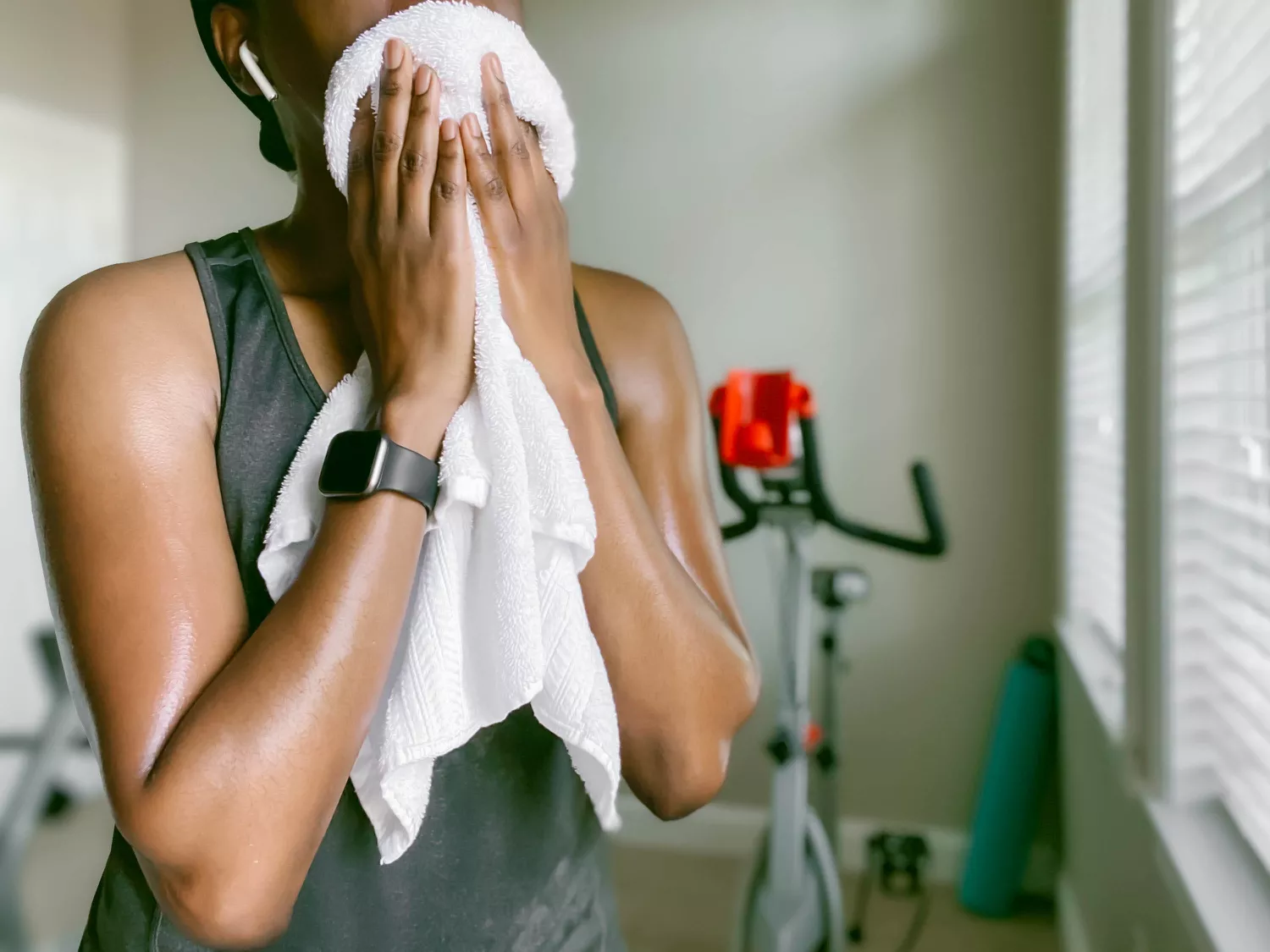 A woman in athletic attire drying off with a white towel after a morning session.
