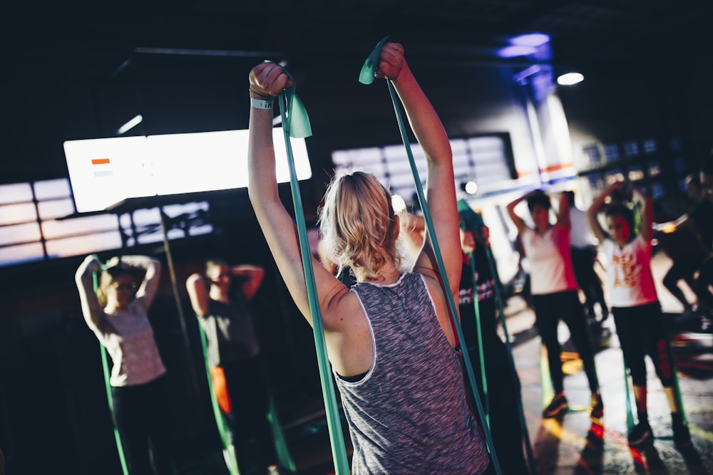 A woman performing dynamic stretching and mobility exercises on a mat.