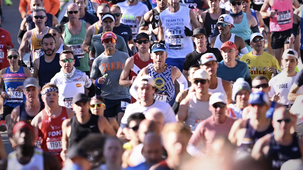 A large group of athletes participating in a crowded city marathon.