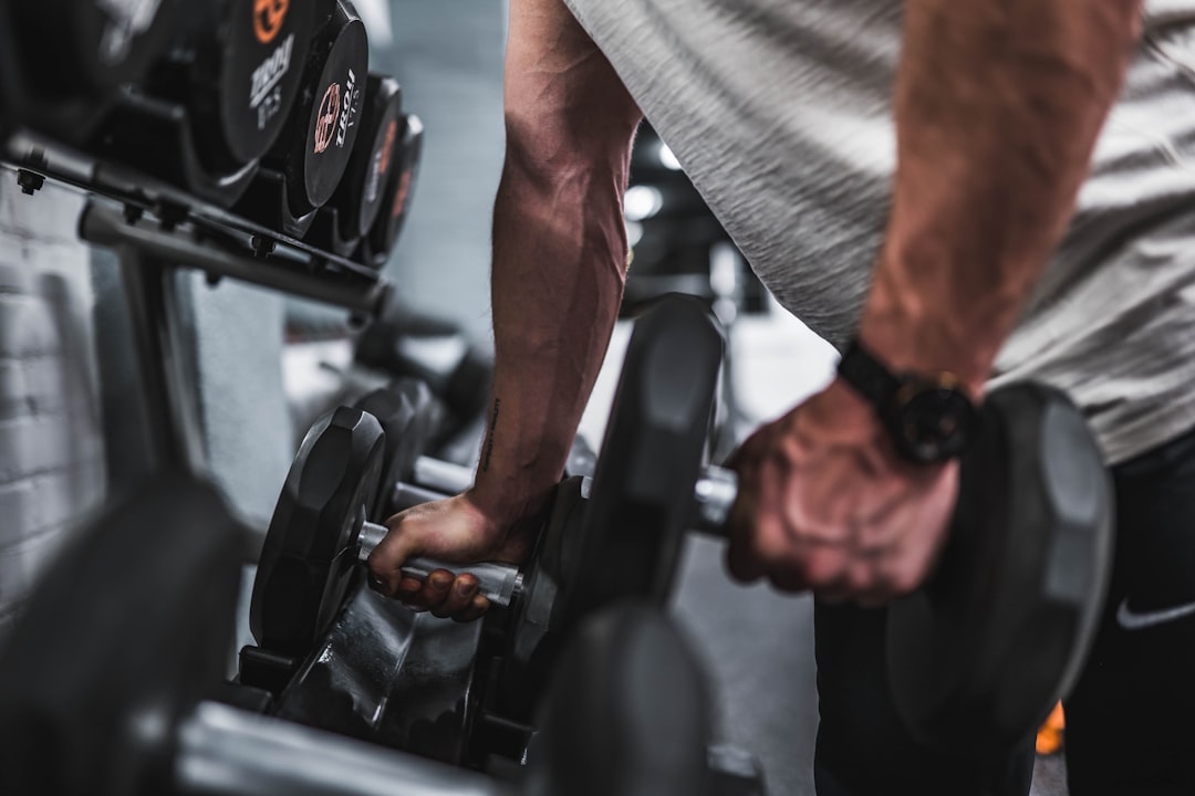 A variety of kettlebells in different sizes and colors arranged on a gym floor.