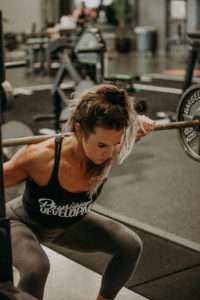 A person performing a squat to demonstrate flexion and extension within the sagittal plane.