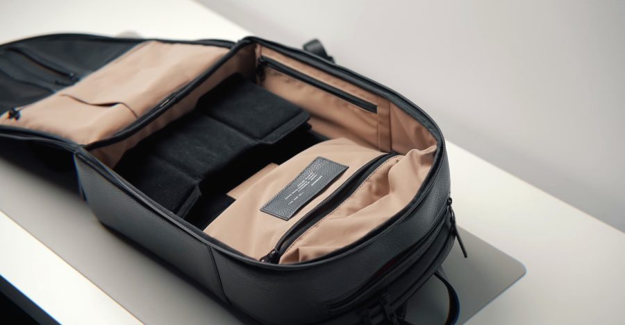 An open travel backpack showing a suitcase-style internal compartment for organized packing.