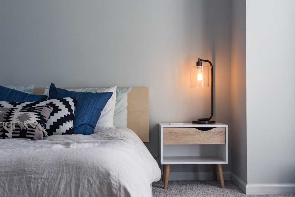 A clean, minimalist bedroom setup with white bedding and soft natural light.