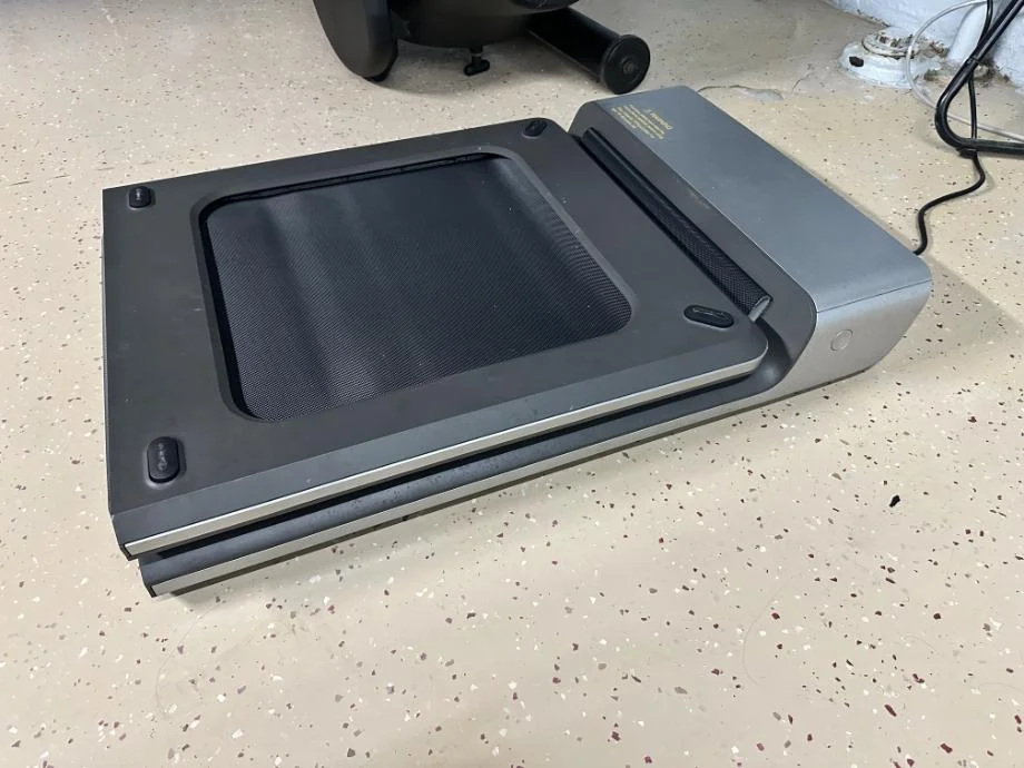A slim WalkingPad treadmill shown folded completely in half for storage.