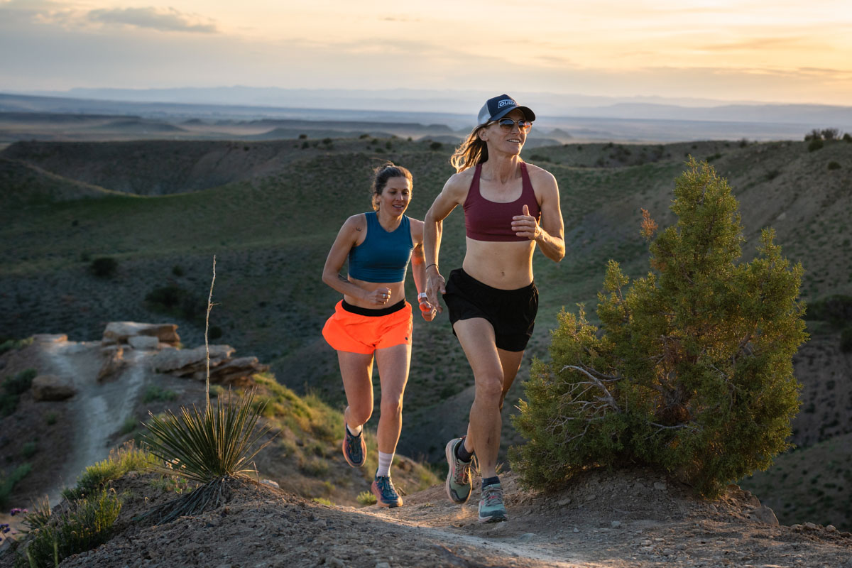 Two women of different body types wearing supportive sports bras while running.