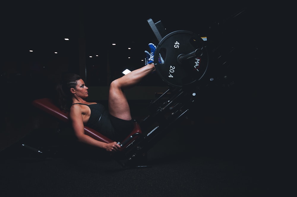 An athlete performing a standing quad stretch in an outdoor setting.