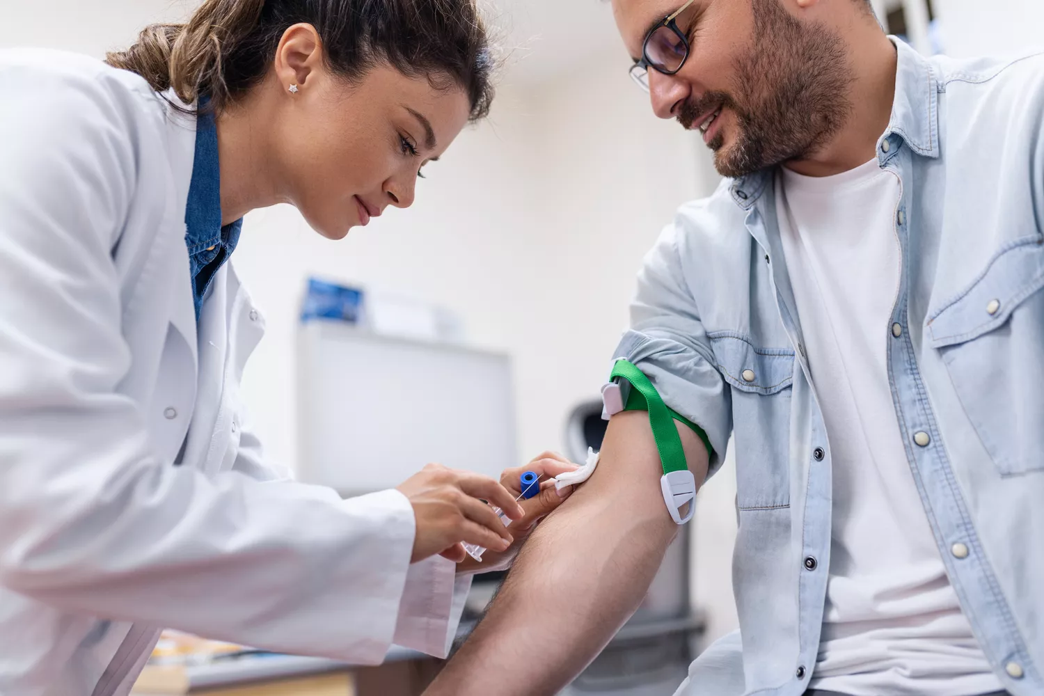 A medical professional preparing a patient's arm for a blood draw.