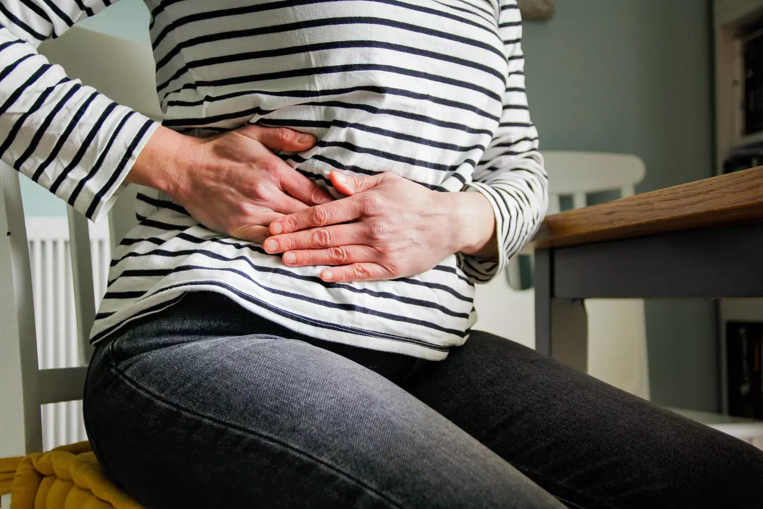 A person holding their side in discomfort due to kidney stone symptoms.