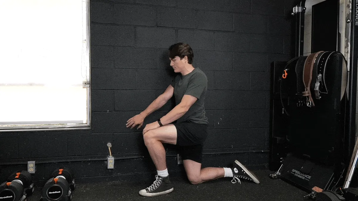 A person performing a shoulder controlled articular rotation against a wall.