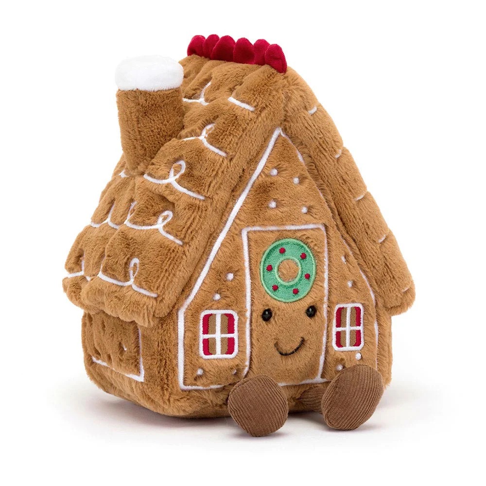 Plush gingerbread house toy with a smiling face.