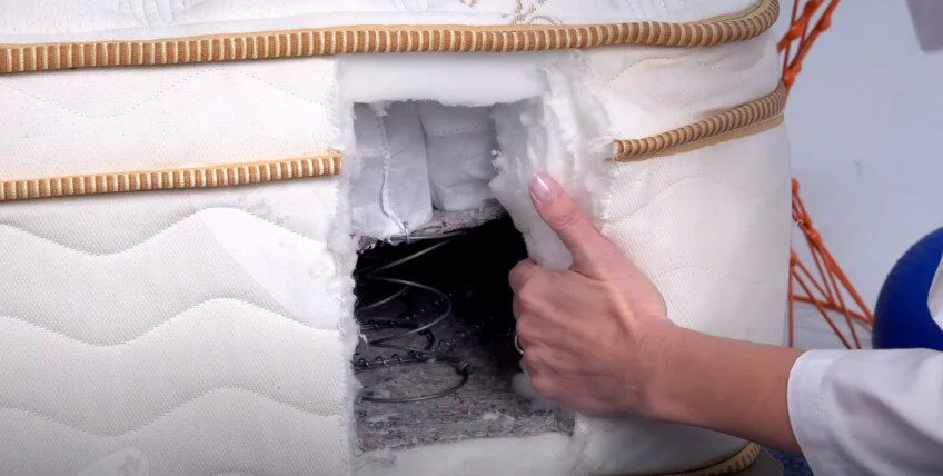 A cross-section view of a mattress showing its internal foam and coil layers.