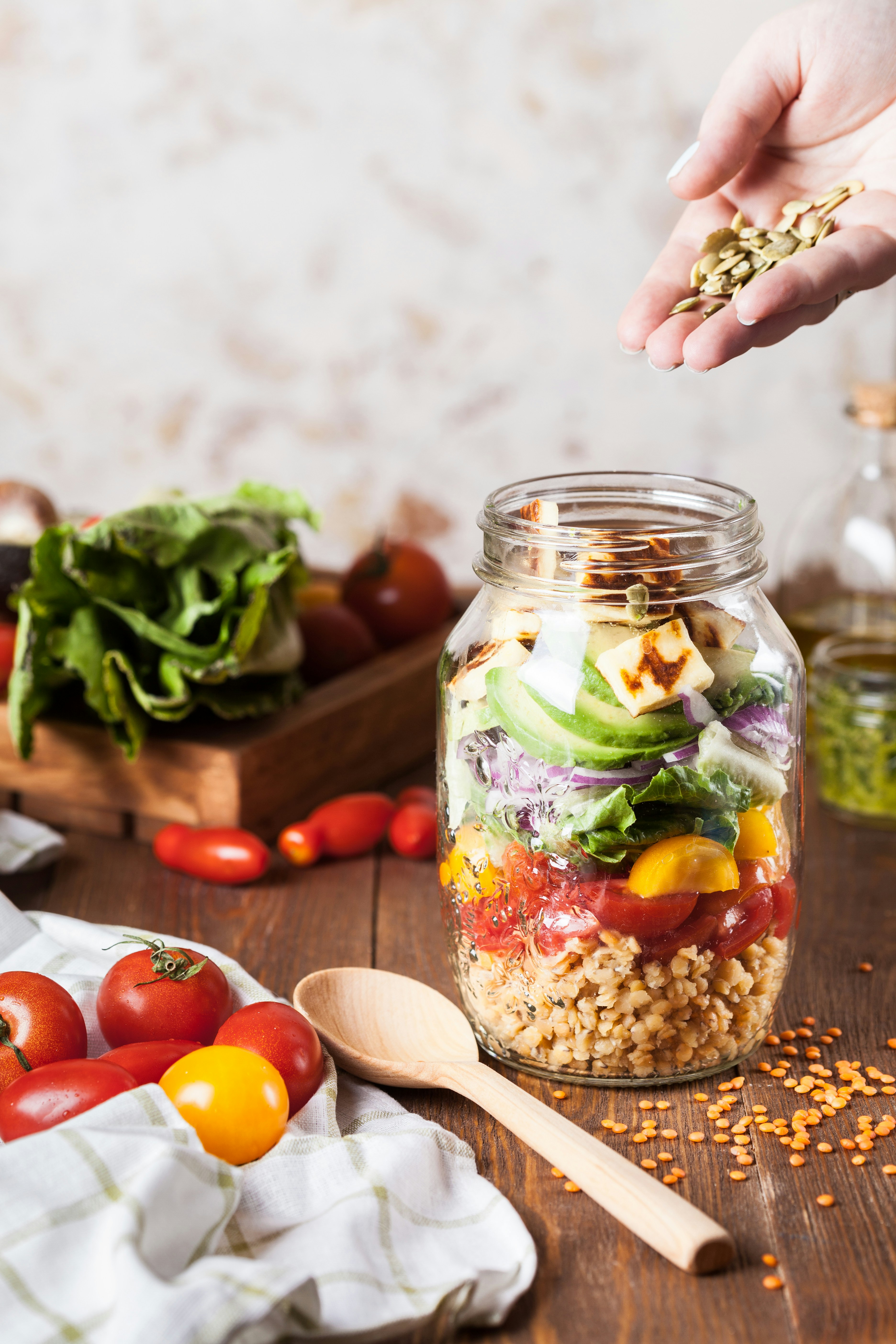 Glass jars filled with various dried legumes, beans, and seeds on a shelf.