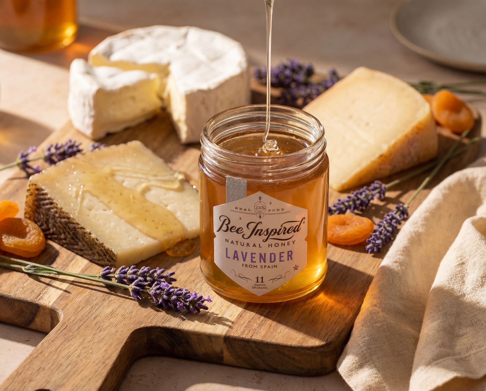 A honey jar and cheese board presentation garnished with fresh lavender sprigs.