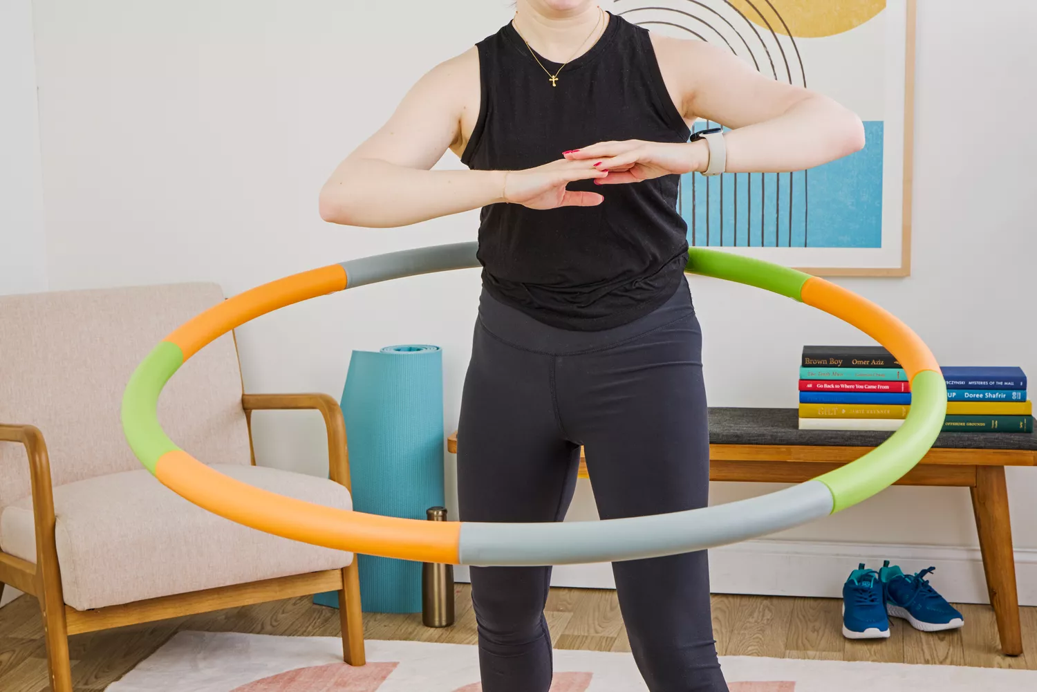 Close-up of a woman using a colorful weighted hoop focusing on the abdominal area.