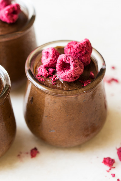 A healthy vegan chocolate mousse served in a small ceramic pot, emphasizing natural ingredients.