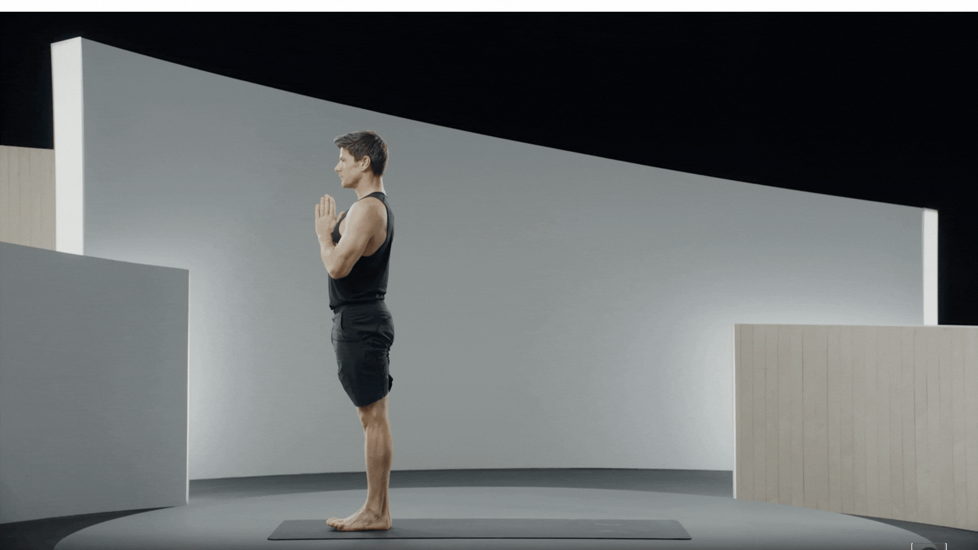 A man demonstrating a movement within the Sun Salutation A sequence.