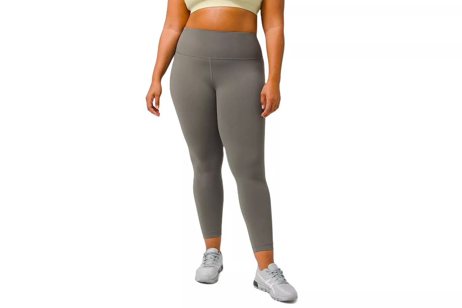 A plus-size woman modeling gray high-rise athletic leggings and a matching top.