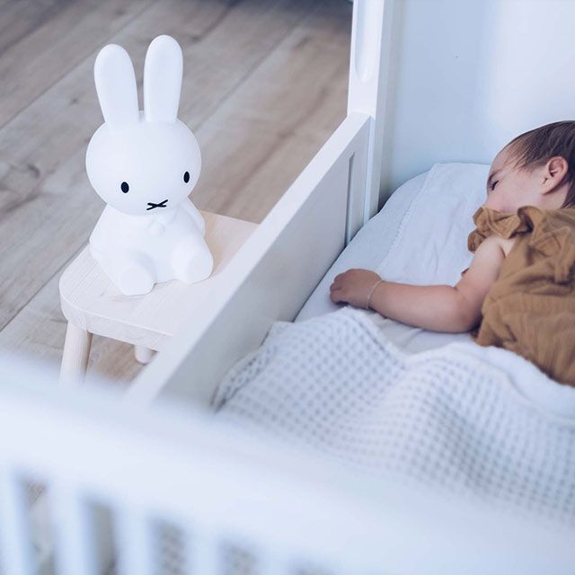 A white minimalist rabbit-shaped bedside lamp with a soft glow.