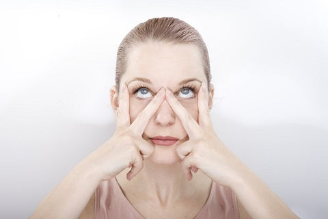 A person performing a facial exercise focused on the mouth and lip area to reduce fine lines.
