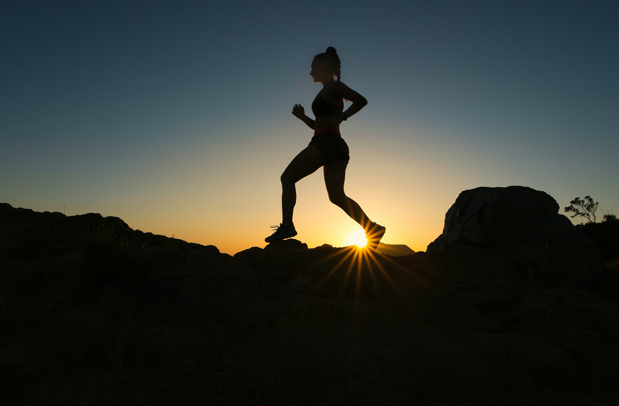 An exhausted athlete leaning over and breathing heavily after a high-intensity interval session.