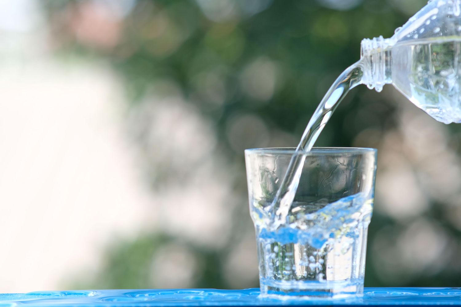 Close-up of fresh water being poured from a bottle into a glass.