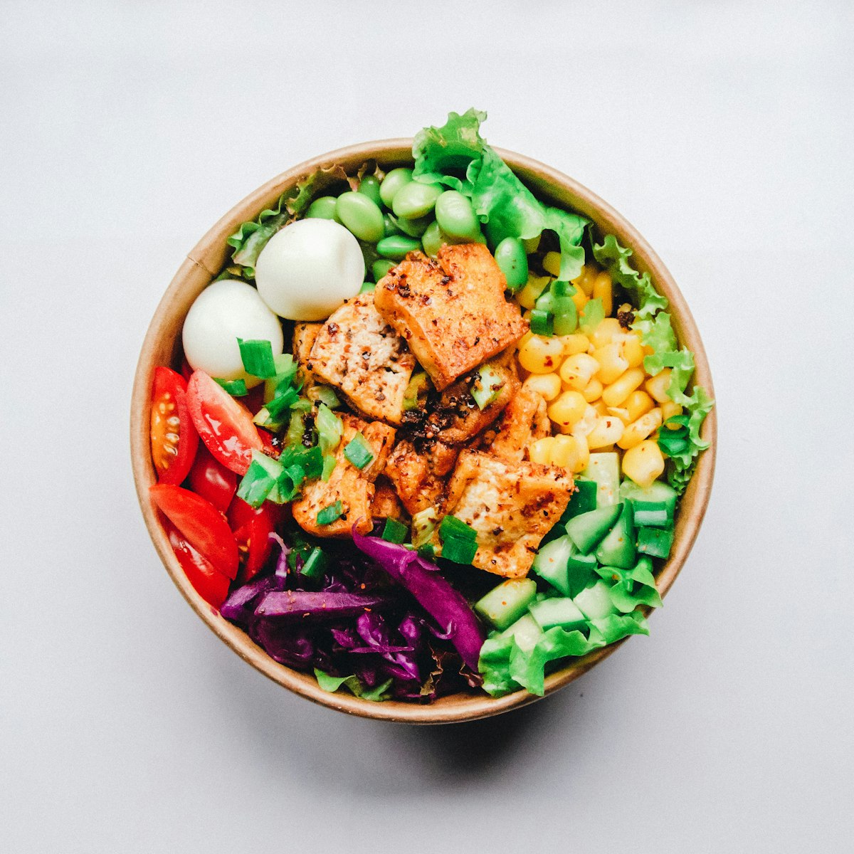 A healthy harvest bowl containing quinoa, avocado, chickpeas, and roasted seasonal vegetables.