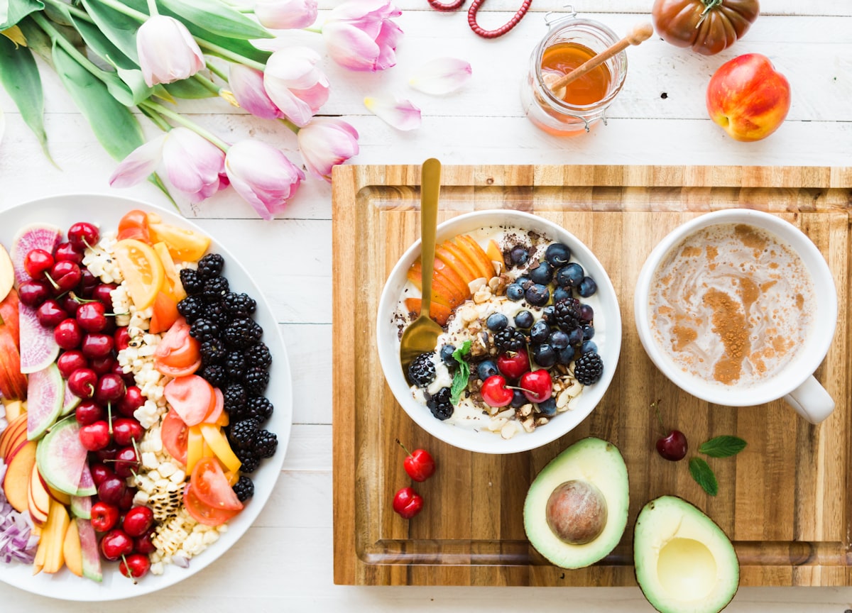 A bowl of thick Greek yogurt topped with blueberries, raspberries, and pumpkin seeds.
