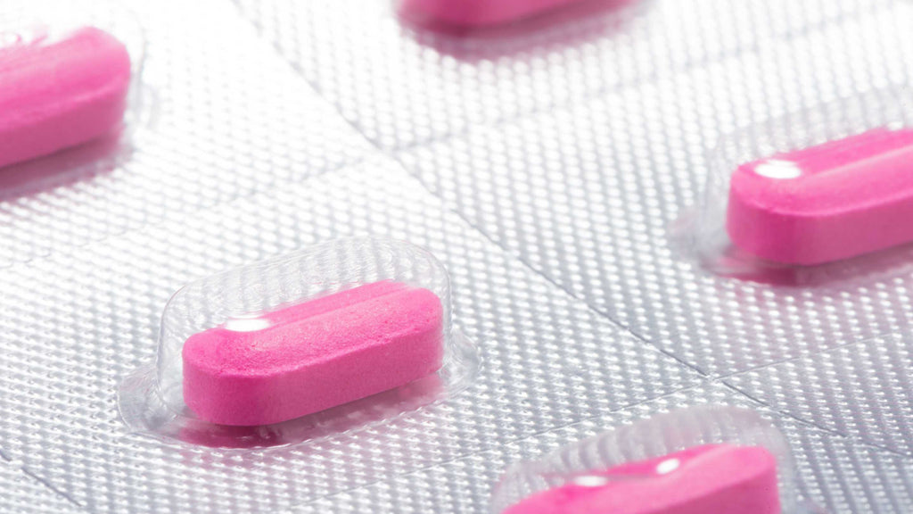 A blister pack of medical capsules against a neutral background.