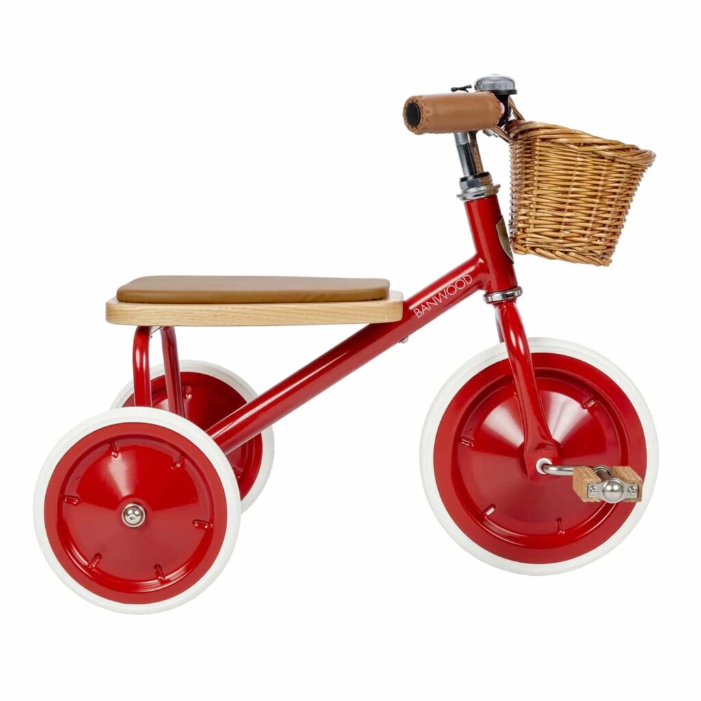 Minimalist cream-colored tricycle with a wicker basket.