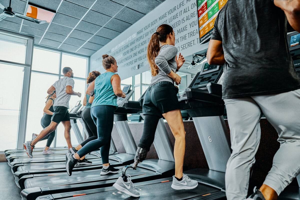 Orangetheory Fitness studio featuring rows of treadmills and water rowers