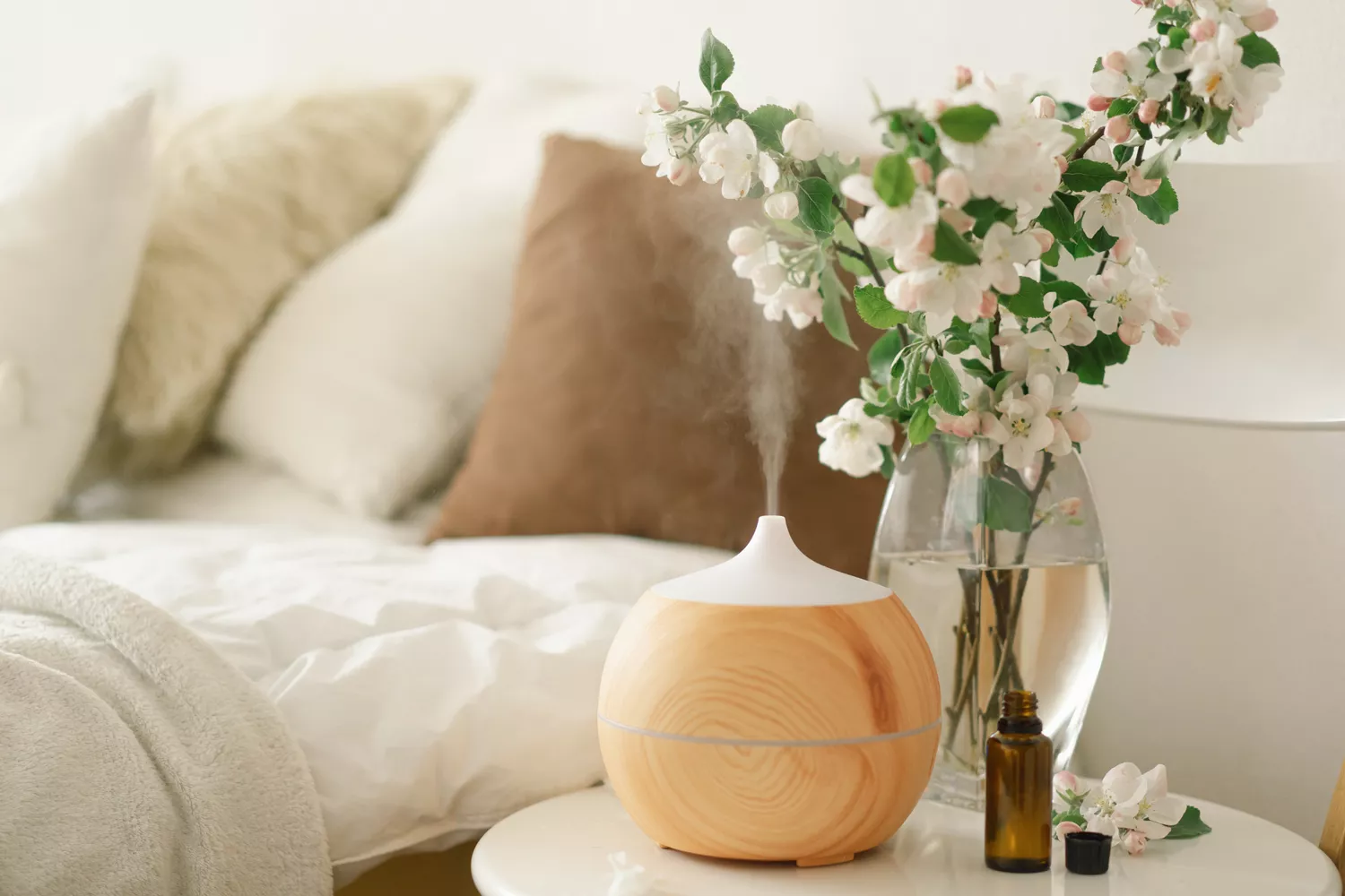 An active aromatherapy diffuser on a bedside table during the evening.