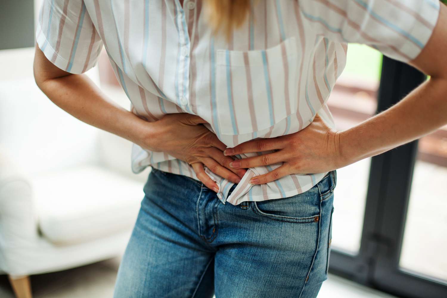 A person holding their midsection indicating internal gas or bloating discomfort.