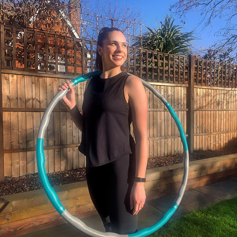 Fitness instructor Rachel demonstrating hula hoop dance movements.