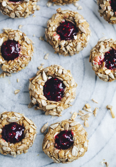Golden thimble cookies filled with red jam on a baking sheet. (SEO: easy no bake healthy Easter cookies).