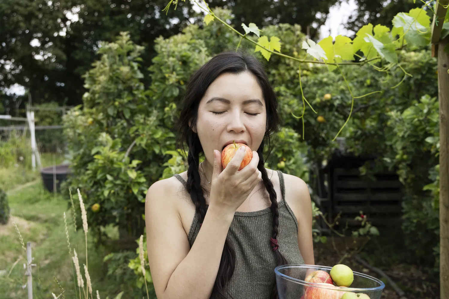 A person enjoying a fresh red apple outdoors as a simple snack.