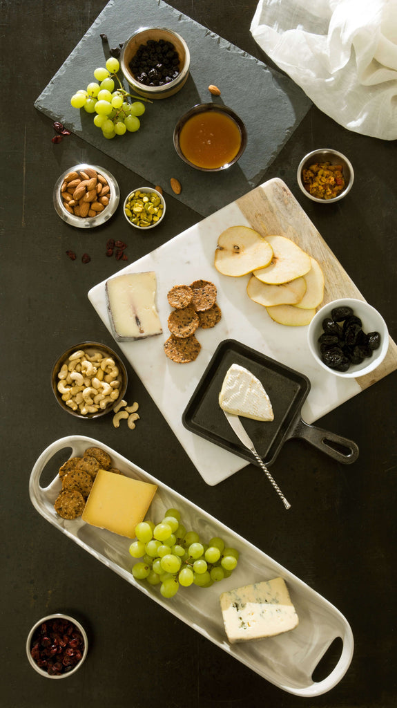 Overhead view of a complete charcuterie board with pears, nuts, and various cheeses.
