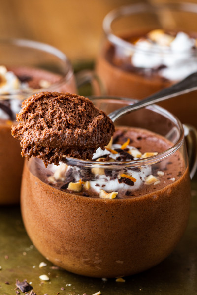 A silver spoon scooping into a thick, creamy vegan hazelnut chocolate mousse.